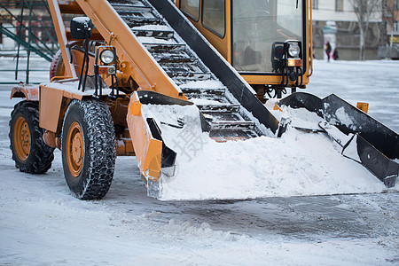 拖拉机从雪中清理道路 挖掘机清理城市大量积雪的街道清洁工机器天气卡车路人车道车轮风暴鼓风机男人背景图片