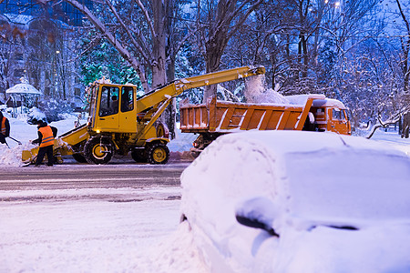 爪式装载机车辆清除道路上的积雪 除雪机将雪倒入卡车服务拖拉机暴风雪街道运输打扫雪堆工人推土机机械图片