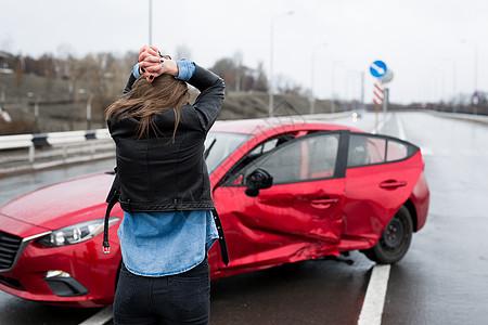 车祸发生后 女人站在破车附近 呼叫救护 汽车保险危险车辆交通街道安全眼泪女性压力保险电话图片