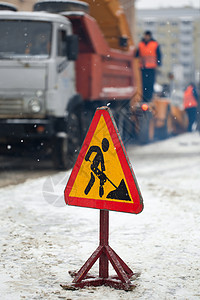 吹雪机用雪和冰清除结冰的冬季道路 除雪机从城市街道上除雪 警告路标 冬季服务车辆吹雪机工作 清洁多雪的结冰道路图片