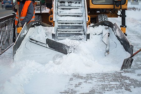 拖拉机从雪中清理道路 挖掘机清理城市中大量积雪的街道 工人在冬天从道路上扫雪 从暴风雪中清洁道路卡车季节机器天气路面车道雪堆机械图片