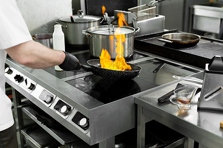 现代厨房 厨师在餐厅或酒店厨房的炉子上准备饭菜 厨房里的火平底锅气体工作油炸用餐烤箱火炉职业燃烧炊具图片