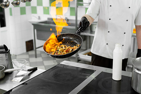 现代厨房 厨师在餐厅或酒店厨房的炉子上准备饭菜 厨房里的火服务烤箱食物烹饪平底锅商业用餐美食盘子工作图片
