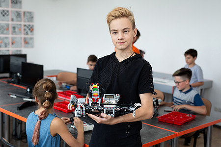 男性学生在放学后计算机编码课上制造机器人车辆的肖像教育笔记本学习电脑工程男生玩具童年技术知识图片