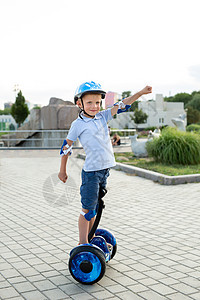 快乐的小男孩骑在悬浮板上 在公园的摩托车上图片