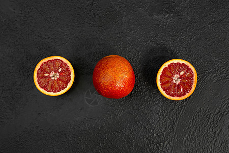 黑色背景的异色橙色卡拉桌子甜点柚子热带叶子果汁早餐饮料液体水果图片