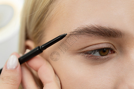 发型师画眉毛 用铅笔给年轻美女魅力成人治疗刷子程序沙龙睫毛膏睫毛眉笔女性图片