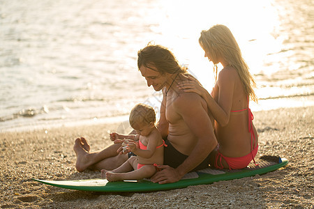 欢乐的家庭坐在冲浪板上 关于家庭 运动和乐趣的概念男人假期热带蓝色冒险泳装孩子冲浪者旅行安全图片