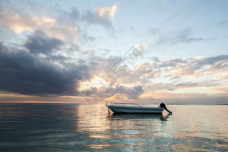与一艘渔船在海洋中美丽的日落橙子海岸海滩钓鱼旅游海景渔夫地平线反射太阳图片
