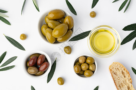 白底底 顶视面有橄榄油和橄榄的小型碗盘白色饮食美食叶子树叶团体木板蔬菜平铺食物图片