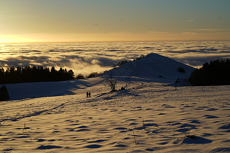 冬季在雪地滑雪 滑雪板或雪橇上放松的概念 日落时在德国黑森州山的夕阳下行走场景森林水杯爬坡木头太阳全景冒险顶峰旅游图片