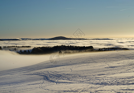 冬季在雪地滑雪 滑雪板或雪橇上放松的概念 日落时在德国黑森州山的夕阳下行走假期天空全景场景森林山脉爬坡环境旅游太阳图片