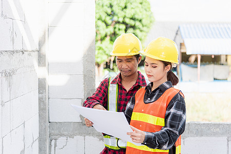 建筑师和客户在施工现场讨论建筑蓝图的计划操作管理人员头盔项目建筑学人士商业工人合作工程图片