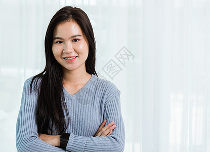 亚裔美丽的女人笑着面朝脸长长的头发横穿手臂幸福皮肤学生快乐女士商业护理卷曲工作室笑脸图片