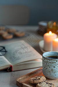 关于冬夜温馨的阅读书 上面有蜡烛 茶叶和饼干桌子咖啡假期静物营养饮料芯片小吃气氛新年图片