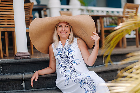 戴大帽子的女人在微笑 毛里求斯岛一座古老的殖民建筑外 一个戴着大帽子和白色连衣裙的漂亮女孩微笑着图片