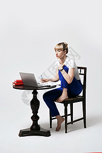 在家看足球赛专注的年轻女性坐在办公桌前工作或远程在线学习 同时在笔记本电脑屏幕上看笔记 在家远程学习或远程工作 孤立在白色背景上辅导团队远程背景