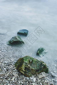 在波浪泡沫中的巨石一行天气崎岖海洋海滩环境支撑海岸线海岸风景冲浪图片