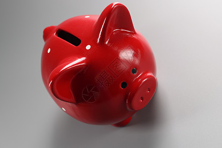灰色表面的红猪银行集装箱 有硬币洞 空陶瓷猪换钱图片