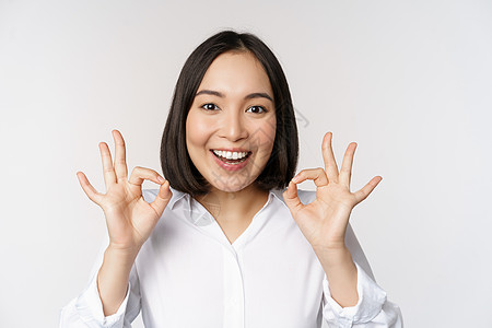 特写亚洲女孩的头像 表现出好的 好的手势和满意的微笑 推荐 高兴 赞美和恭维 白色背景老板员工人士公司成人商业工作室管理人员广告图片