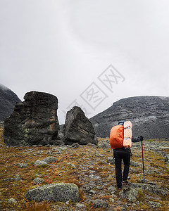 在山岩路上行走的希克人妇女背包游客踪迹自由小路天空远足登山男人旅游图片