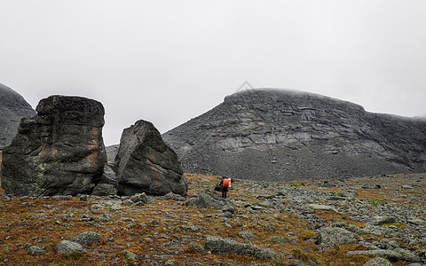 在山岩路上行走的希克人妇女登山天空远足运动旅行蓝色高山背包人行道小路图片