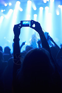 一个用摄像电话拍摄自己最爱的乐队的人 拍了一部摄影机音乐会音乐派对互联网俱乐部享受成人娱乐技术背景图片