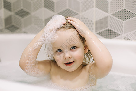 小婴儿洗澡 微笑女孩 保健和儿童卫生的近相肖像画 健康照顾和孩子卫生泡沫微笑喜悦身体护理情感湿头肥皂洗涤浴室图片