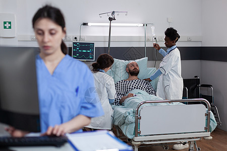 医生团队设置静脉滴注线并咨询患者连接以监测测量生命体征图片