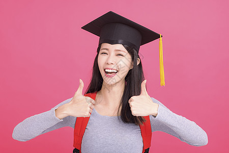 兴奋的亚洲女大学生在毕业上限毕业时表现成功 表现出成功的姿态图片