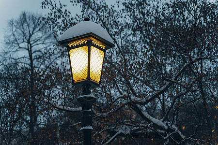 冬季在雪覆盖城市街道上夜灯照亮图片