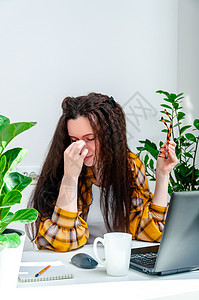 美丽的妇女因为在笔记本电脑上工作而疲劳 给自己擦眼部图片