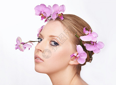 青春美满盛的花朵 一个美丽的年轻女人的演唱室肖像 她头发上有粉红色兰花图片