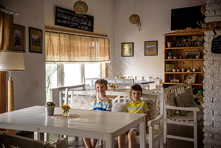 现代室内咖啡店风格 生态环境以及墙上的植物 咖啡店 两个儿童坐在桌旁的长椅上 等待美食食物叶子咖啡标签用餐标识厨房木头质量桌子图片