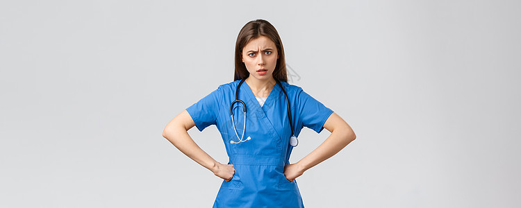医护人员 预防病毒 保险和医学概念 愤怒而沮丧的女护士 身着磨砂膏的医生 手放在腰上 盯着被质疑的镜头 需要解释实习生外科科学女图片