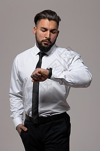 灰色背景的穿着优雅衣服的男人主义马甲深色领带大男子背心性格发型绅士白衬衫图片