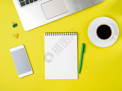 带有空白笔纸 计算机 智能手机的现代亮黄色办公桌面顶端视图 放大 空位商业工作咖啡笔记本技术小样螺旋杯子日记文档图片