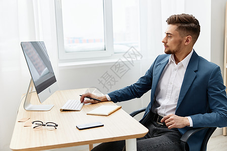 一个穿西装的男人 电脑台式电脑工作 自信心纸文件夹执行官图片