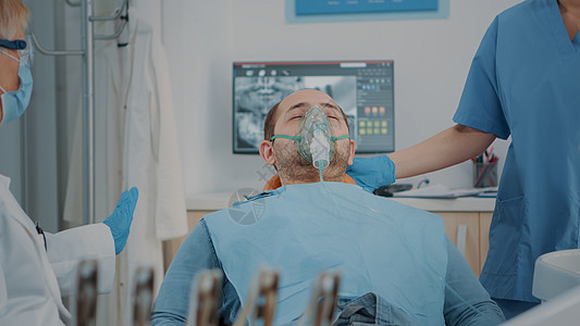 在牙科柜内接受麻醉术的氧气面具患者; 口腔检查室图片
