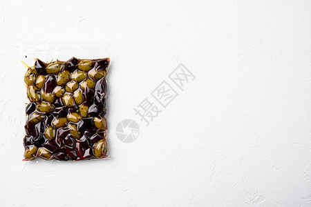 有机橄榄真空袋 在白石桌背景上 顶视平板 有复制文本的空间图片
