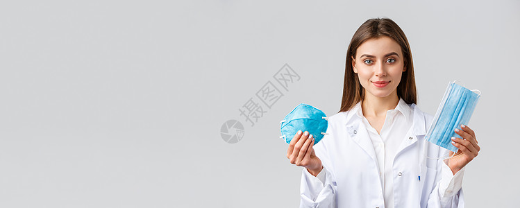Covid19 预防病毒 医护人员的概念 身着磨砂膏的专业迷人女医生 使用保护措施预防冠状病毒爆发的建议 展示呼吸器和医用面罩管图片