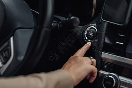 女性在启动或停止现代汽车引擎的按钮上握着手指图片
