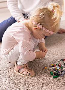 植入人工耳蜗的婴儿在家玩得很开心 耳聋和医疗技术概念女性女孩教育助听器听力学仿生齿轮玩具童年情感图片