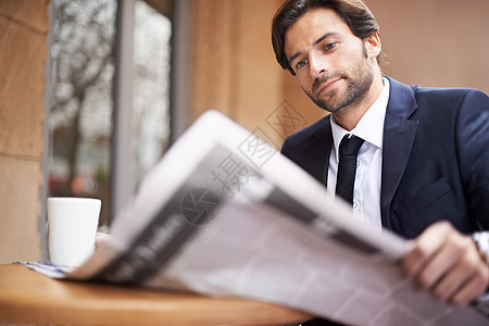 今日商业界发生的事 一个年轻商务人士 在咖啡店户外看报纸的书了 他是个大生意人图片