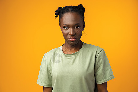黄色背景下 带着怀疑和不满表情的美丽非洲女性学生情感爆炸姿势成人女孩黑色工作室黑发商业图片