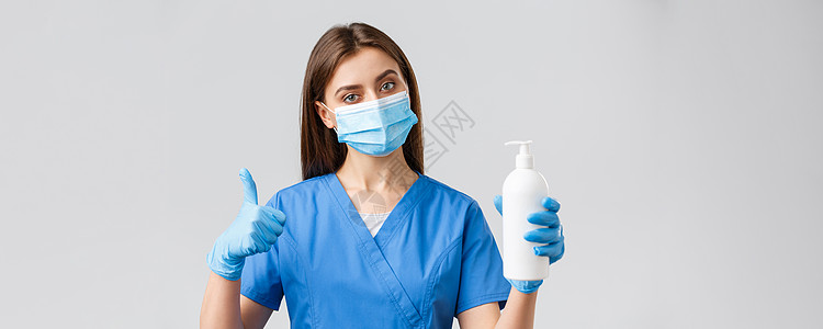 Covid19 预防病毒 医护人员的概念 身着蓝色磨砂膏 医用口罩和手套的严肃女护士或医生 建议使用肥皂或消毒剂对抗冠状病毒感染图片