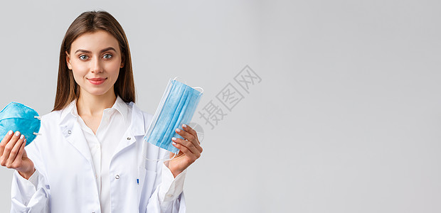Covid19 预防病毒 医护人员的概念 身着磨砂膏的专业迷人女医生 使用保护措施预防冠状病毒爆发的建议 展示呼吸器和医用面罩疫图片