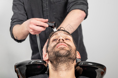 理发店 美发师在理发店洗客户头洗发水男性造型师胡须头发职业洗涤服务发型师奢华图片