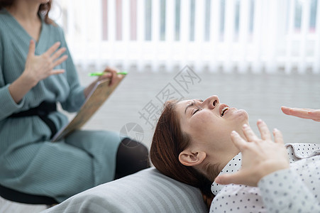 一位白人女性在与心理学家会面时躺在沙发上哭泣悲伤写作客户笔记心理治疗师会议说谎压力心理学图片