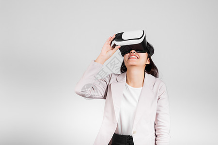 在虚拟现实经历期间 微笑的女性自信兴奋地佩戴VR头盔装置图片